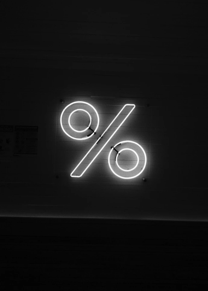 A glowing neon percentage sign on a dark background